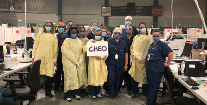 Group photo of CHEO staff at the Brewer arena, wearing masks and gowns
