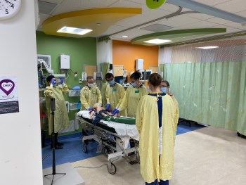 Staff gathered around a mannequin for a simulation